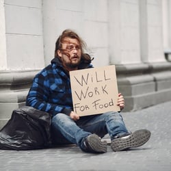 Homeless in a city. Man asking for food. Man with a tablet